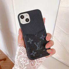 a woman holding up her phone case with the louis vuitton logo on it