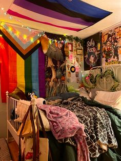 a bedroom with many colorful sheets and decorations on the walls, including a rainbow flag