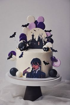 a halloween themed cake on a plate with balloons and bats in the air above it