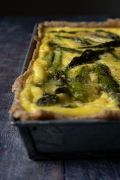 a quiche with asparagus and cheese in a pan