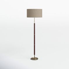 a floor lamp with a brown shade on it's side and a white background