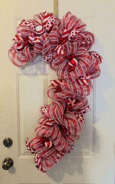 a red and white wreath hanging on the front door