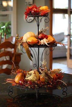 a three tiered tray filled with fruit and vegetables on top of a black table