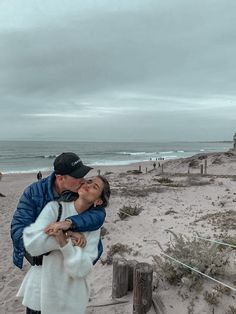 a man and woman embracing on the beach