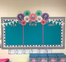 a classroom wall decorated with colorful paper flowers