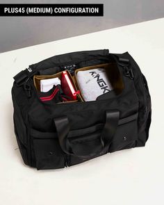 a black duffle bag filled with items sitting on top of a white countertop