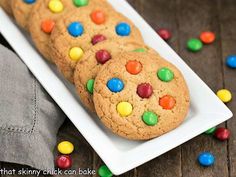 a white plate topped with a giant cookie covered in m & m cookies and candy