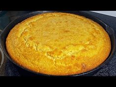 a cake in a pan sitting on top of a stove next to a frying pan