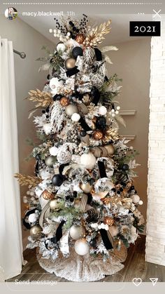 a white christmas tree with black and gold ornaments