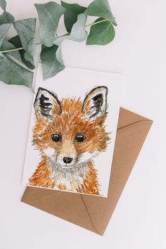 a card with a watercolor painting of a baby fox on it's face