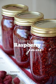 three jars filled with raspberry jam sitting on top of a table