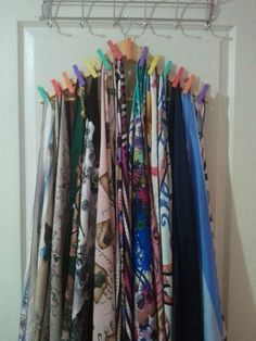 there are many scarves hanging on the rack