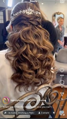 the back of a woman's head with long curly hair and a tiara