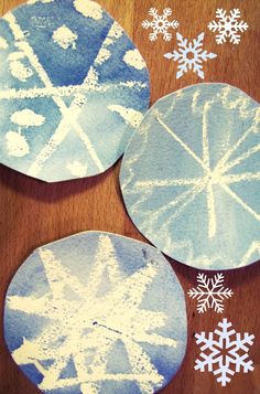 three snowflakes are on the table and one is blue with white snow flakes