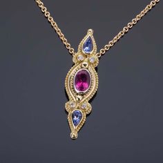 An exquisite jewelry piece fit for royalty, this 18K gold classical pendant is encrusted with a delicious 0.86ct rubellite, accented with gorgeous tanzanites and sparkling diamonds. Bold and elegant, this piece of jewelry exemplifies the concept of "treasure" and is sure to capture the eye of every admirer. Crafted in 18K gold & 950 palladium. Set with a center 0.86ct rubellite tourmaline, 0.53cts of tanzanite, and 0.06cttw VS/GH diamonds. (Chain sold separately)Dimensions: 1-3/8” x 3/8” (35mm x Elegant Sapphire Multi-stone Necklace, Elegant Multi-stone Oval Pendant Jewelry, Elegant Multi-stone Oval Pendant Necklace, Rubellite Tourmaline, Tanzanite Diamond, Exquisite Jewelry, Sparkle Diamonds, The Eye, Tourmaline