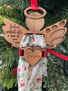 "Personalize this Angel Fabric Keepsake Ornament with your loved one's name to keep them close at heart. Made from Cherry Hardwood ply & ribbon, this keepsake will be passed down from generation to generation. Use fabric from your loved one's shirt, apron, or other fabric article and thread through the center opening. Use the attached ribbon with heart charm to secure the fabric.  Includes a 3/8\" wide red ribbon for hanging." Shirt Ornament Keepsake, Angel Fabric, Fabric Angel, Shirt Apron, Keepsake Ideas, Christmas Tree Decorating Themes, Memory Crafts, Cherry Hardwood, Memory Pillows