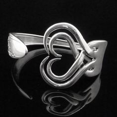 a silver ring with the letter e in it's center on a black background