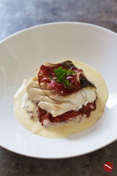 a white plate topped with meat covered in sauce