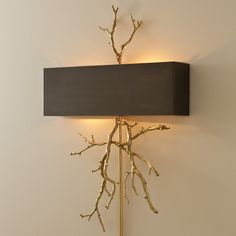 a wall light with branches on it and a black box hanging from the back side