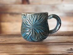 a blue coffee mug sitting on top of a wooden table