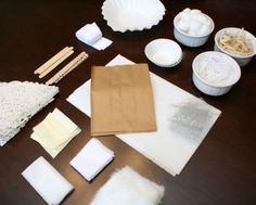 the table is covered with different types of crafting supplies including paper plates, napkins and bowls