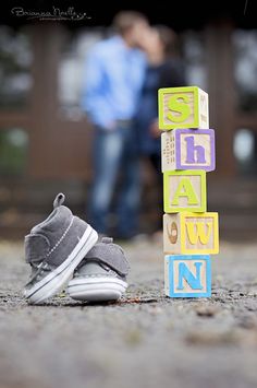 a pair of shoes sitting on the ground next to blocks that spell out name names