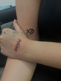 two people with tattoos on their arms sitting next to each other