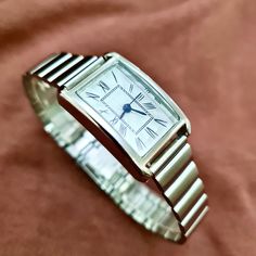 Woman Wrist Watch, Silver Colour Watch, Roman Numeral Dial, Rectangle Design Watch, Modern Design Watch, Easy Adjustable Band, White Dail, Gift for Her, Mother's Day Gift, Valentine's Day Gift, Present for Her, Daily Usage Diamensions: - Case Thickness: 9 mm - Total Lenght: 22,5 cm - Case Diameter: 25 mm x 20 mm - Weight: 45 gr Classic Analog Rectangular Watch Accessories, Classic Square Watch Accessories For Gifts, Formal Watch Accessories With Bracelet Strap And Rectangular Dial, Timeless Rectangular Bracelet Strap Watch Band, Formal Rectangular Watch With Metal Dial, Classic Silver Rectangular Watch Accessories, Silver Rectangular Analog Watch, Timeless Silver Rectangular Watch Bands, Silver Classic Rectangular Watch Bands