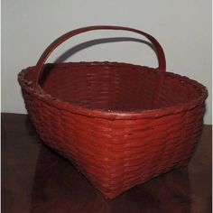 a red basket sitting on top of a wooden table