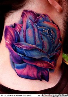 a woman's neck with a blue and purple rose tattoo on it