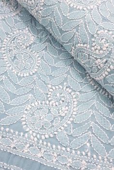 the fabric is blue and has white flowers on it, as well as an intricate design