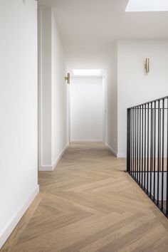 an empty hallway with white walls and wooden floors