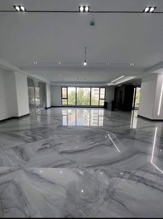 an empty room with marble floors and large windows