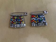 two pairs of multicolored beaded earrings sitting on top of a table next to each other