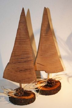 two small wooden sailboats sitting on top of a piece of wood