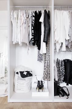 an organized closet with clothes and handbags on the shelves, including black and white accessories