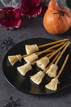 there are many small pieces of food on the black plate next to two pumpkins