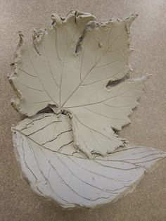 a leaf shaped bowl sitting on top of a table