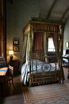 a bedroom with a four poster bed and antique furniture