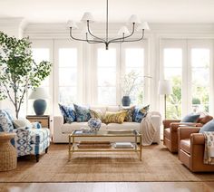 a living room with couches, chairs and lamps on the windowsills is shown