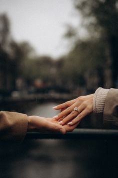 two people holding each other's hands on a rainy day