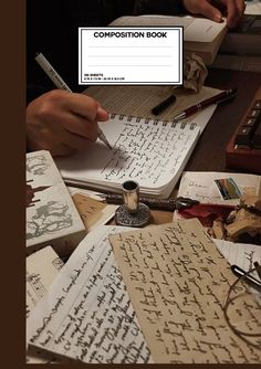 a person is writing on a book with some typewriters in front of them