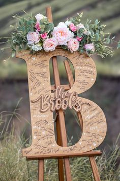 a wooden easel with flowers and writing on it