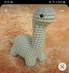 a small crocheted toy sitting on top of a furry surface