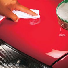 a person wiping down the hood of a red car with a microfiber cloth