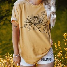 *Images are an accurate depiction of what you'll receive upon purchase. 🌿Blending art, nature and vintage charm, we introduce our Minimalist Mum Comfort Color TShirt, part of our new Spring Collection.  Indulge in the timeless beauty of our hand drawn floral tshirt, where artistry meets comfort. This unique tee showcases a stunning hand-drawn illustration of a beautiful mum, each petal carefully rendered to perfection. Crafted on Comfort Colors, known for its luxurious 100% cotton and vintage-i Botanical Graphic Print Relaxed Fit Shirt, Botanical Relaxed Fit Graphic Shirt, Botanical Style Relaxed Fit Graphic Print Shirt, Relaxed Fit Botanical Graphic Print Shirt, Botanical Print Relaxed Fit Shirt, Botanical Printed Relaxed Fit Shirt, Botanical Style Relaxed Fit Short Sleeve Shirt, Botanical Short Sleeve Cotton Tops, Botanical Graphic Print Cotton Shirt