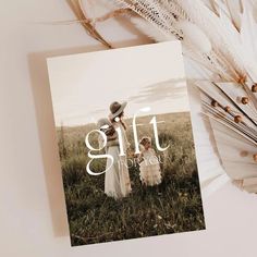 a card with the words gift on it next to feathers