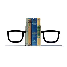 a pair of black glasses sitting on top of two bookshelves filled with books