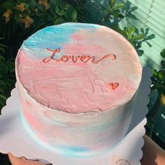 someone holding up a cake with the word loved on it