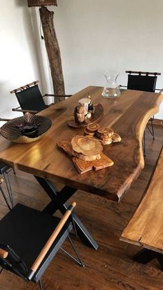 a wooden table with chairs around it and plates on top of the table next to it